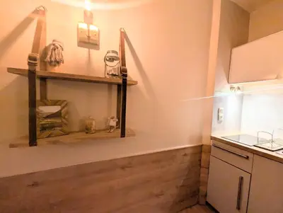 a kitchen with wooden floors and a counter and a shelf at Au Petit Bois in Chamonix-Mont-Blanc