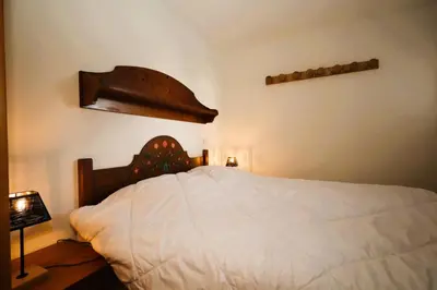 a bedroom with a white bed with a wooden headboard at Résidence Les Hauts De Chavants - Hauts de chavants Albert 1er n°1 MAE-6254 in Les Houches