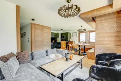 a living room with a couch and a table at Mont d'arbois, 3 chambres avec terrasses et sauna dans la résidence in Megève