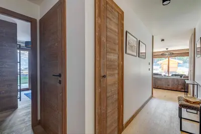 a hallway with a wooden door in a house at Mont d'arbois, 3 chambres avec terrasses et sauna dans la résidence in Megève