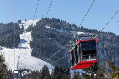 a red ski lift going up a snowy mountain at Mont d'arbois, 3 chambres avec terrasses et sauna dans la résidence in Megève