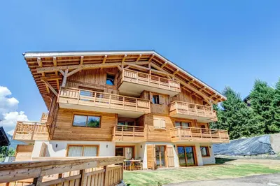 a large wooden house with balconies and a fence at Mont d'arbois, 3 chambres avec terrasses et sauna dans la résidence in Megève