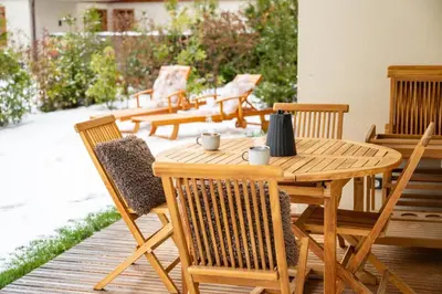 a wooden table and chairs on a patio at Mont d'arbois, 3 chambres avec terrasses et sauna dans la résidence in Megève