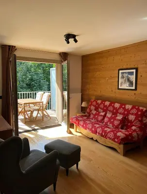 a living room with a red bed and a balcony at White Pearl in Chamonix-Mont-Blanc