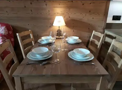 a wooden table with plates and wine glasses on it at White Pearl in Chamonix-Mont-Blanc