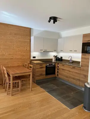 a kitchen with a table and a ceiling fan at White Pearl in Chamonix-Mont-Blanc