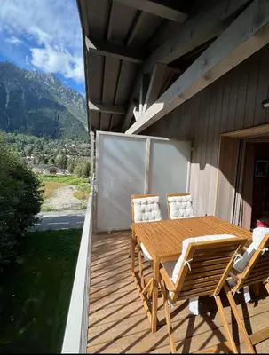 a wooden deck with a table and chairs on a house at White Pearl in Chamonix-Mont-Blanc