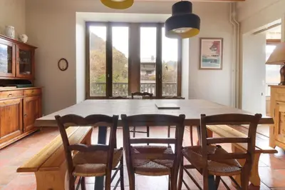 a dining room table with chairs and a large window at Saint Éloi - Panoramic view - Mont Joly - Central in Saint-Gervais-les-Bains