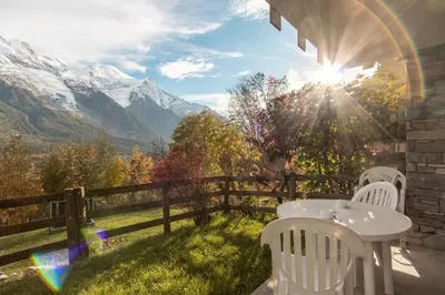 a table and chairs on a balcony with a view of mountains at Le Crétet 2 - Best views of the Mont-Blanc in Chamonix-Mont-Blanc