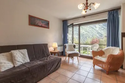 a living room with a couch and a large window at Le Crétet 2 - Best views of the Mont-Blanc in Chamonix-Mont-Blanc