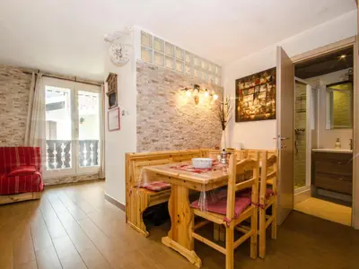 a dining room with a wooden table and chairs at Studio 2* central avec balcon et WiFi - FR-1-343-235 in Chamonix-Mont-Blanc