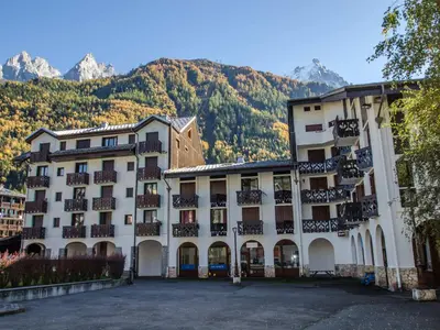 a hotel with mountains in the background at Studio 2* central avec balcon et WiFi - FR-1-343-235 in Chamonix-Mont-Blanc