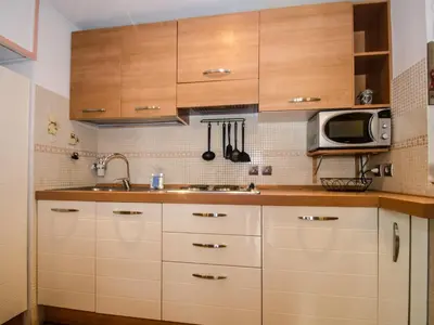 a kitchen with wooden cabinets and a microwave at Studio 2* central avec balcon et WiFi - FR-1-343-235 in Chamonix-Mont-Blanc