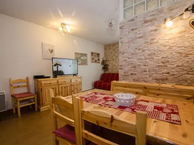 a dining room with a table and a brick wall at Studio 2* central avec balcon et WiFi - FR-1-343-235 in Chamonix-Mont-Blanc