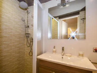 a bathroom with a sink and a shower with a mirror at Studio 2* central avec balcon et WiFi - FR-1-343-235 in Chamonix-Mont-Blanc