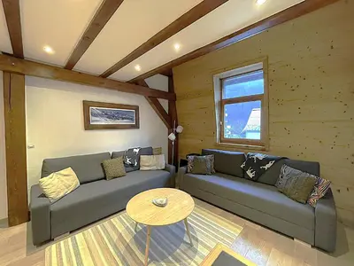 a living room with a couch and a table at Duplex centre Chamonix pour 6 avec parking et wifi - FR-1-343-240 in Chamonix-Mont-Blanc