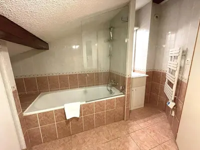 a bathroom with a bath tub and a sink at Duplex centre Chamonix pour 6 avec parking et wifi - FR-1-343-240 in Chamonix-Mont-Blanc
