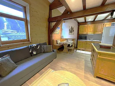 a living room with a couch and a kitchen at Duplex centre Chamonix pour 6 avec parking et wifi - FR-1-343-240 in Chamonix-Mont-Blanc