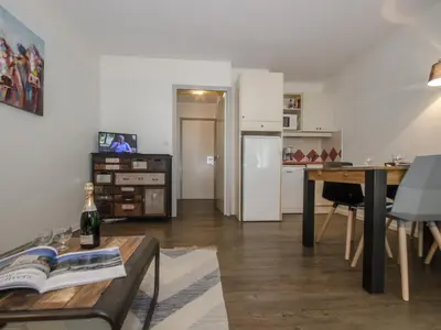a living room with a table and a white refrigerator at Studio à Chamonix avec balcon, 4 personnes - FR-1-343-238 in Chamonix-Mont-Blanc