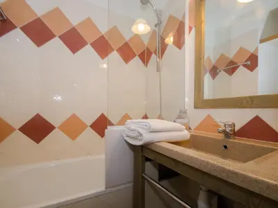 a bathroom with a sink and a tub and a mirror at Studio à Chamonix avec balcon, 4 personnes - FR-1-343-238 in Chamonix-Mont-Blanc
