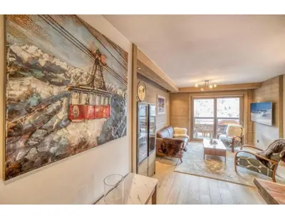 a living room with a large painting on the wall at Luxurious 4-room with pool, gym, spa and parking in Megève