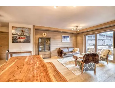 a living room with a couch and a table at Luxurious 4-room with pool, gym, spa and parking in Megève