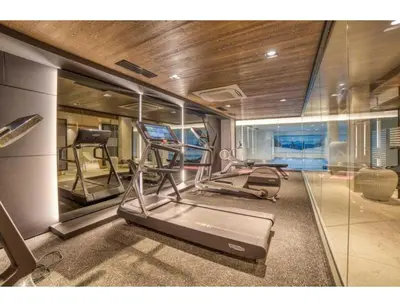 a gym with two treadmill machines and a glass wall at Luxurious 4-room with pool, gym, spa and parking in Megève