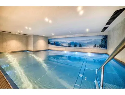 a large indoor swimming pool in a building at Luxurious 4-room with pool, gym, spa and parking in Megève
