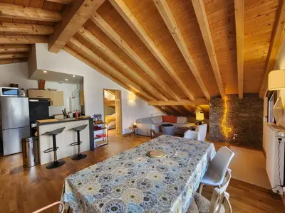 a living room with a table and a kitchen at Atypique T4 lumineux avec vue panoramique, 3 Ch, 6-8 pers, WIFI, parking couvert - FR-1-629-112 in Samoëns