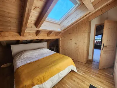 a bedroom with a large bed with a skylight at Atypique T4 lumineux avec vue panoramique, 3 Ch, 6-8 pers, WIFI, parking couvert - FR-1-629-112 in Samoëns