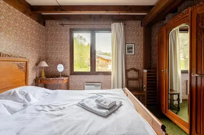 a bedroom with a bed with towels on it at Chalet Les Charmilles - Vallée de Chamonix - 5 chambres in Les Houches