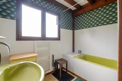 a bathroom with a green tub and a window at Chalet Les Charmilles - Vallée de Chamonix - 5 chambres in Les Houches