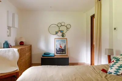 a bedroom with a bed and a dresser at Chalet Les Charmilles - Vallée de Chamonix - 5 chambres in Les Houches