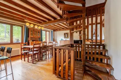 a kitchen and dining room with a staircase in a house at Chalet Les Charmilles - Vallée de Chamonix - 5 chambres in Les Houches