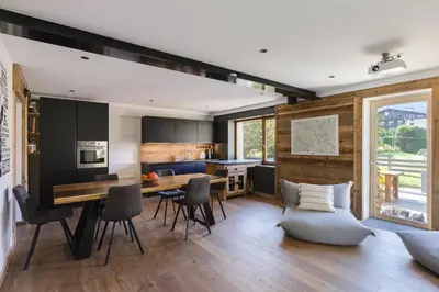 a kitchen and living room with a table and chairs at Chalet Benoit - Modern Chalet 8 Pax Free Parking Mountain View - By Cozee Rentals in Chamonix-Mont-Blanc