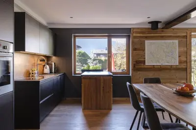 a kitchen with a wooden table and a dining room at Chalet Benoit - Modern Chalet 8 Pax Free Parking Mountain View - By Cozee Rentals in Chamonix-Mont-Blanc