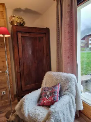 a pillow on a blanket in a room with a window at LE GRAND TETRAS in Samoëns
