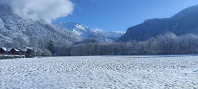 a snow covered river with mountains in the background at LE GRAND TETRAS in Samoëns