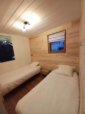 a bedroom with two beds in a log cabin at Bel appartement familial et cosy in Saint-Gervais-les-Bains