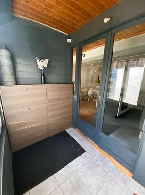 a room with a large glass door with a vase of flowers at Bel appartement familial et cosy in Saint-Gervais-les-Bains