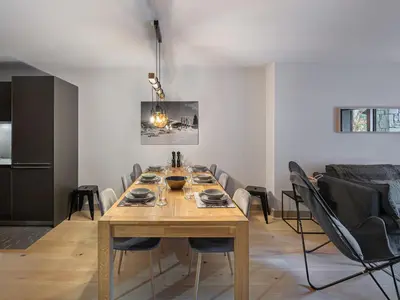a dining room with a wooden table and chairs at Appartement cosy à Rochebrune, piscine et parking - FR-1-569-58 in Megève