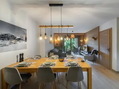 a dining room with a wooden table and chairs at Appartement cosy à Rochebrune, piscine et parking - FR-1-569-58 in Megève