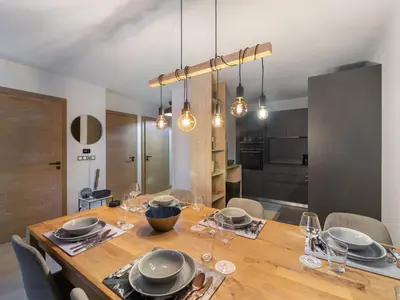 a dining room with a wooden table with glasses at Appartement cosy à Rochebrune, piscine et parking - FR-1-569-58 in Megève
