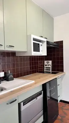 a kitchen with white cabinets and a microwave at STUDIO DENT DU CAIMAN, CHAMONIX hyper CENTRE, PARKING, VUE MONT BLANC in Chamonix-Mont-Blanc