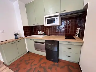 a kitchen with white cabinets and a microwave at STUDIO DENT DU CAIMAN, CHAMONIX hyper CENTRE, PARKING, VUE MONT BLANC in Chamonix-Mont-Blanc