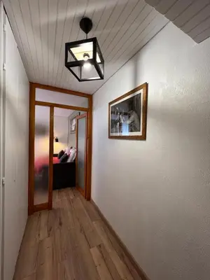a living room with a hallway with a light and a mirror at STUDIO DENT DU CAIMAN, CHAMONIX hyper CENTRE, PARKING, VUE MONT BLANC in Chamonix-Mont-Blanc