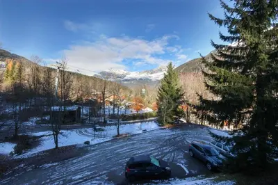 two cars parked in a parking lot in the snow at Le Goûter - Ski-in ski-out - Indoor Pool in Les Houches