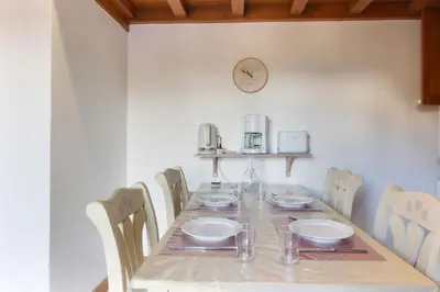 a long table with chairs and a clock on the wall at Le Goûter - Ski-in ski-out - Indoor Pool in Les Houches