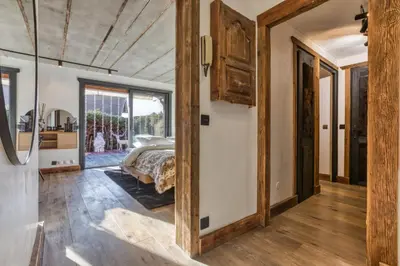 a bedroom with a bed and a door leading to a bathroom at Le petit cœur de Megève -Mont770- in Megève