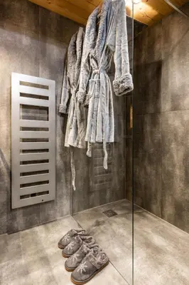 a room with a glass shower with a towel and shoes at Le petit cœur de Megève -Mont770- in Megève
